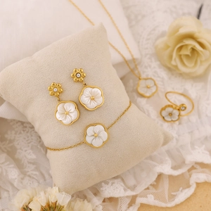 Détail de la parure en acier doré 18 carats avec pétales de fleurs en nacre blanche