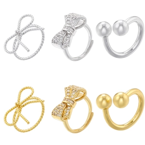 Close-up of twist bow rings and double bead open bands with cubic zirconia in silver and gold