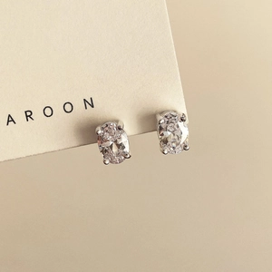 Macro shot of oval-cut crystal stud earrings with classic four-prong silver setting