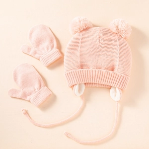 Warm pink knit baby hat with double pom poms and earflaps with matching mittens set