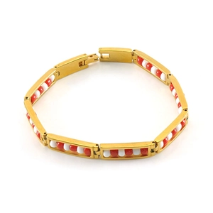Macro shot of 18K gold plated steel chain bracelet featuring red and white bead charms