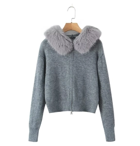Detail of grey knitted sweater featuring a plush faux fur collar and dual zipper hardware