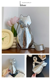 Detail of silver cat-shaped shoulder bag with glossy metallic finish and wide strap