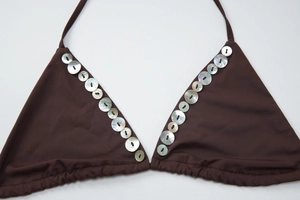 Detail of brown bikini top featuring iridescent shell button accents and triangle cup design