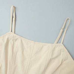 Detailed shot of cream cotton maxi dress featuring adjustable straps and vertical seams
