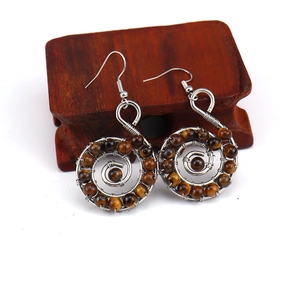 Detail of handmade silver wire spiral earrings with natural brown tiger eye stone beads