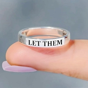 Close-up view of silver titanium steel ring with LET THEM engraving for men and women