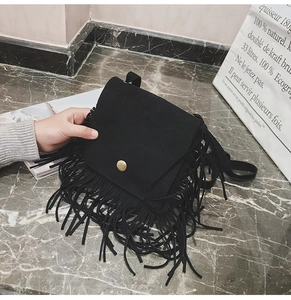 Detail of black suede fringe crossbody bag for kids with gold buckle and long tassels