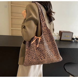 Detail of leopard print tote bag with pink side tie bow knot in a lifestyle setting