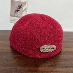 Classic deep red wool beret with adjustable metal logo tag for elegant winter styling