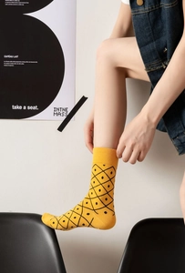 Detailed close-up of a yellow cotton sock featuring a black pineapple jacquard pattern