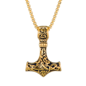 Detailed close-up of golden Thor's hammer pendant with intricate Nordic engravings