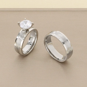 Detailed view of silver stainless steel couple rings with a sparkling solitaire diamond