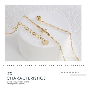 Close-up of gold chain necklace with zircon-encrusted cross and adjustable lobster clasp