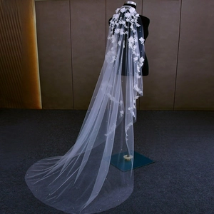 Detail of white bridal veil featuring 3D handmade flowers and delicate pearls decoration