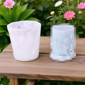 Close-up of white silicone candle mold with embossed elk pattern on a wooden table