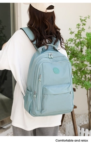 Outdoor shot of a light blue multi-compartment nylon backpack with adjustable straps