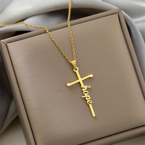 Macro detail of gold stainless steel cross necklace featuring an elegant Hope script pendant