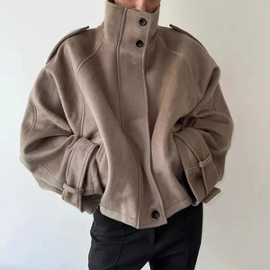 Close-up of beige standing collar wool jacket featuring shoulder epaulettes and strap cuffs