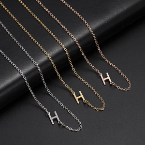 Detail of 26 letter H pendants in silver gold and rose gold stainless steel finishes