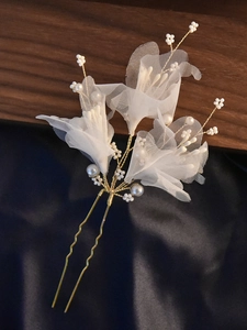 Detail of handmade bridal hair pin with white organza flowers and pearls on gold wire