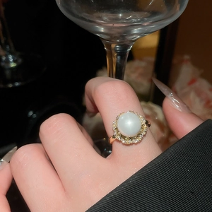 Detailed close-up of a French vintage gold ring with large pearl and sparkling zircons