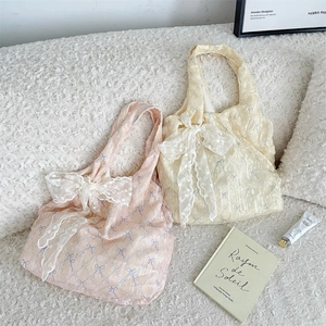 Détails de sacs cabas en toile pastel avec de grands nœuds en dentelle et fleurs