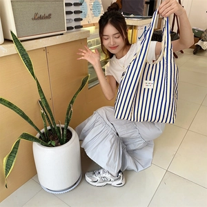 Close-up of blue and yellow striped canvas tote bag with woven texture and logo label