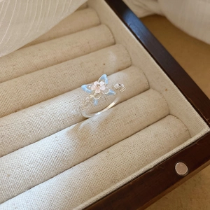 Macro shot of light blue and pink flower ring displayed in a soft cream jewelry box