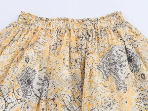 Detail of elastic waistband on yellow floral print skirt with abstract patterns