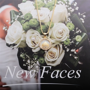 Elegant gold shell necklace with a zircon-encrusted round pendant over white roses