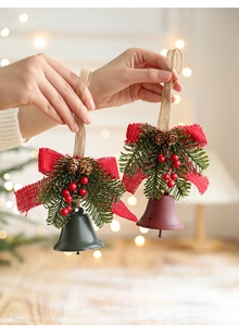 Detail of Christmas iron bells with pine cones and berries held in a cozy festive setting