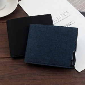 Flat lay of slim bifold wallets in black and blue fabric texture on a desk with a magazine