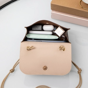 Chic monogram mini crossbody bag with drawstring strap showing internal storage capacity
