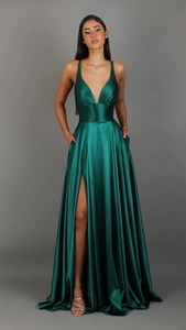 Detail of emerald green satin evening dress featuring a high slit and side pockets