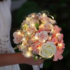 Dettaglio di bouquet con luci LED a perla e rose rosa per un'atmosfera romantica