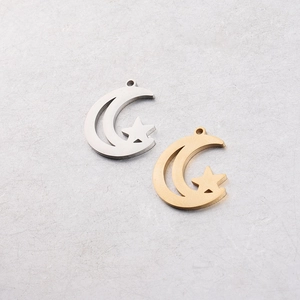 Detail of hollow moon and star charms in gold and silver mirror finish steel