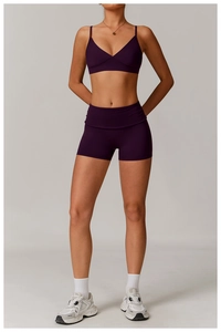 Front view of plum purple yoga set featuring V-neck sports bra and high-waisted shorts