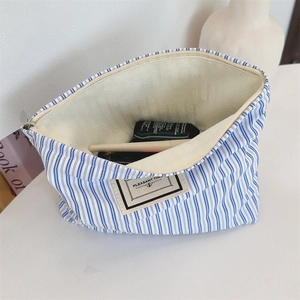 Close-up of blue striped cotton makeup bag with metal zipper and high storage capacity