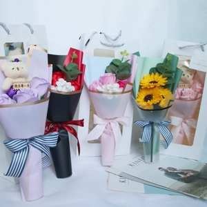 Detail of soap flower bouquets with plush bears and gift bags in assorted vibrant colors