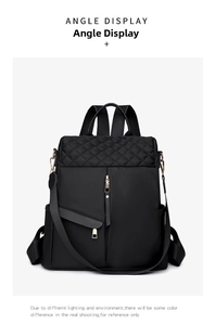 Front angle display of black nylon quilted backpack with gold zippers and hardware