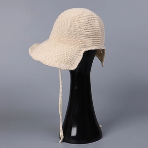 Detail of breathable cream knit sun hat with elegant tie straps on a display stand