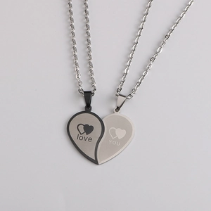 Détail de pendentifs cœur emboîtables en noir et argent avec gravure love YOU
