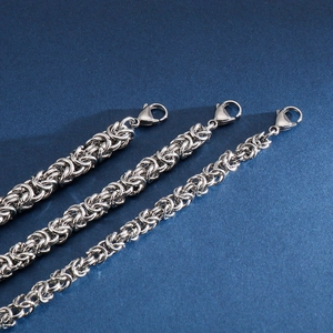 Macro shot of silver Byzantine stainless steel chains showcasing intricate braided texture
