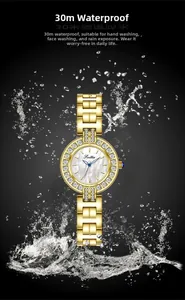Détail d'une montre dorée étanche avec cadran en nacre, strass brillants et éclaboussures d'eau