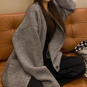 Detail of loose dark grey knit cardigan with a marled texture and large pockets