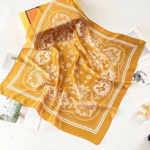 Detail of a ginger silk-feel square scarf with paisley pattern and elegant decor