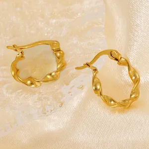Vue détaillée des créoles torsadées plaquées or 18 carats sur du satin champagne doux