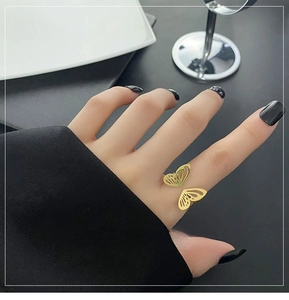 Close-up of golden butterfly open ring on finger with hollow wing design and elegant finish