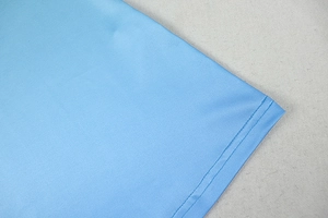 Detailed close-up of sky blue knitted fabric hem featuring precise double-needle stitching